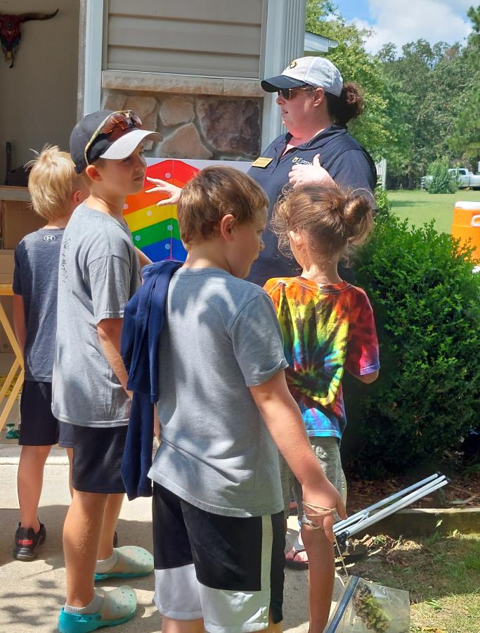 kids gathered around veggie station presenter